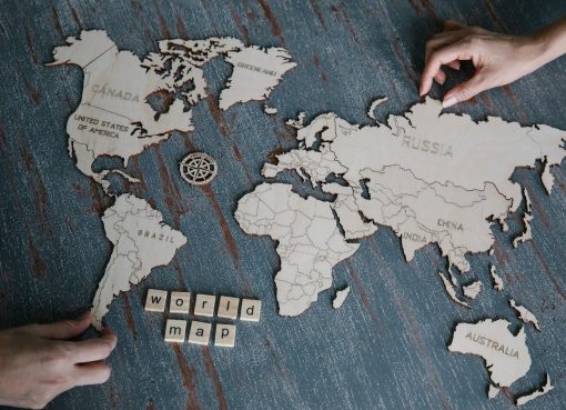 hands and wooden world map