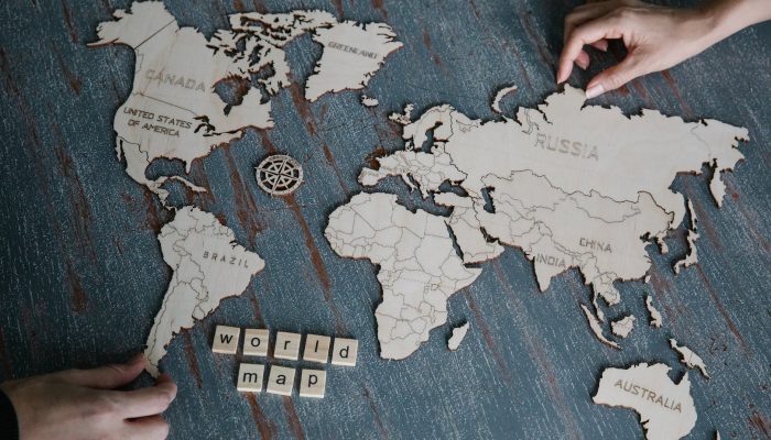 hands and wooden world map