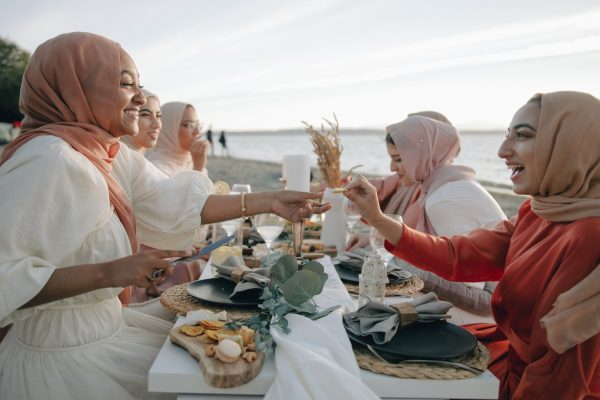 women in hijab having picnic on the beach