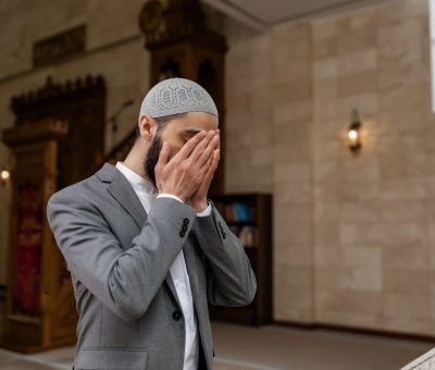 a man in gray suit covering his face