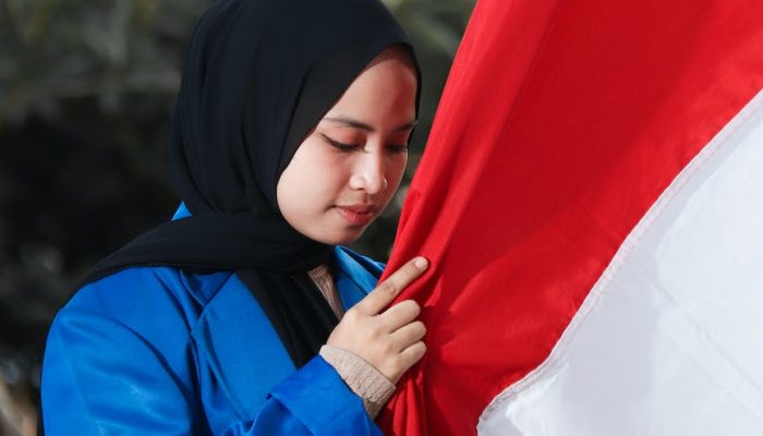 a woman holding the flag of indonesia