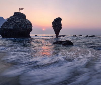 cliffs in sea near coast at sunset