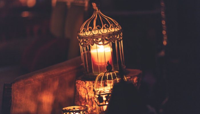 photo of brown metal cage with lighted candle