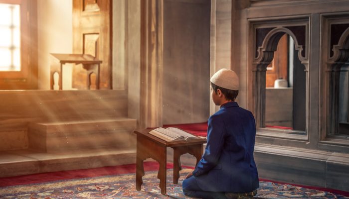 photo of person kneeling in front of a book