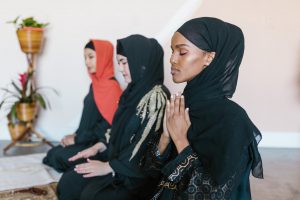 women in black hijab praying
