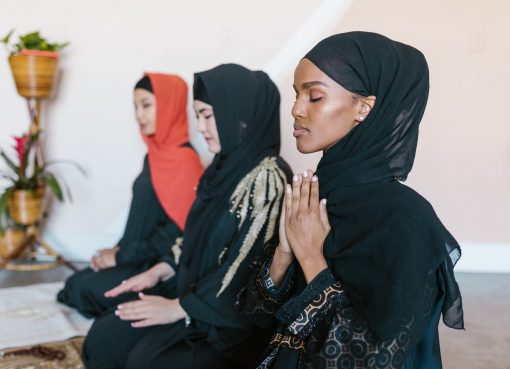 women in black hijab praying