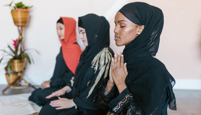 women in black hijab praying
