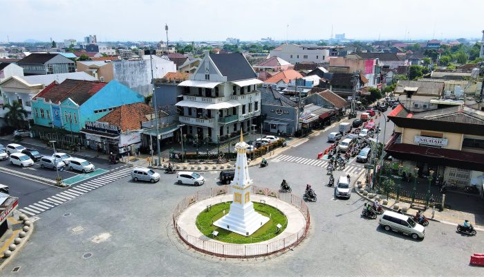 an aerial photography of moving cars on the road near the tugu yogyakarta