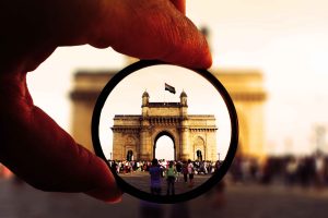 person holding round glasses in shallow photo