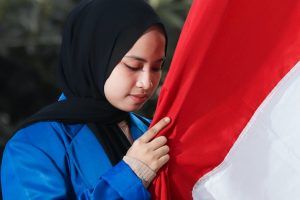 a woman holding the flag of indonesia