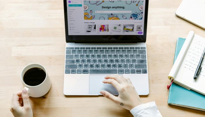 faceless person using touchpad on laptop