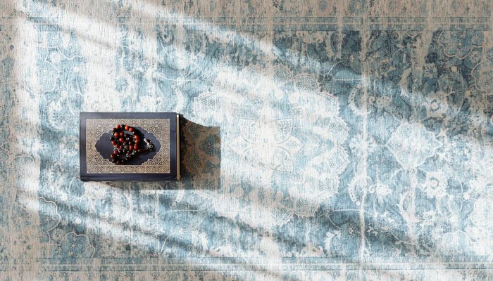prayer beads on top of quran on a prayer rug